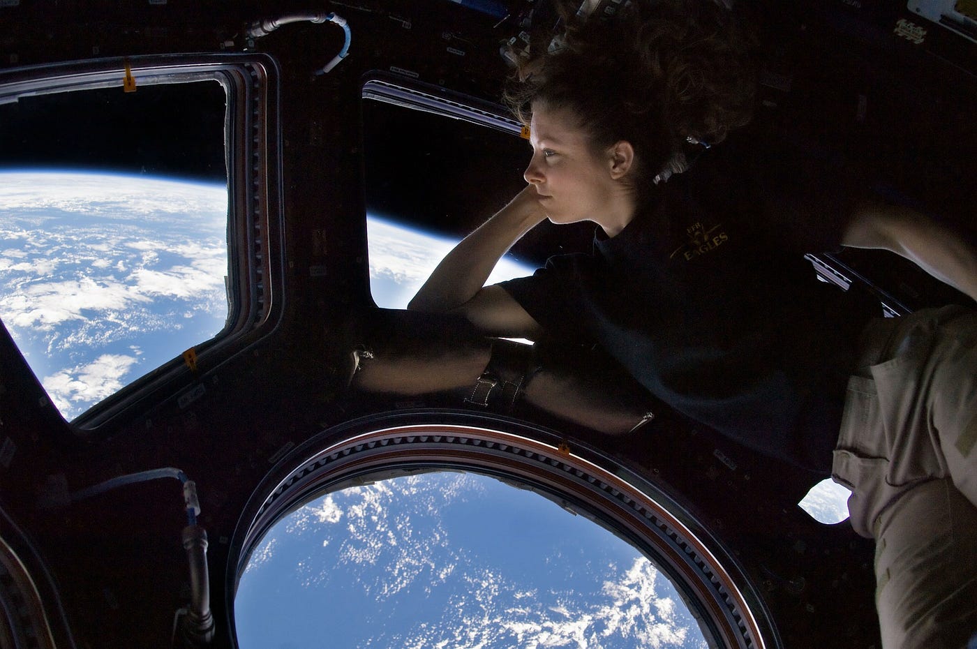 An astronaut gazes at Earth from a window of the International Space Station.