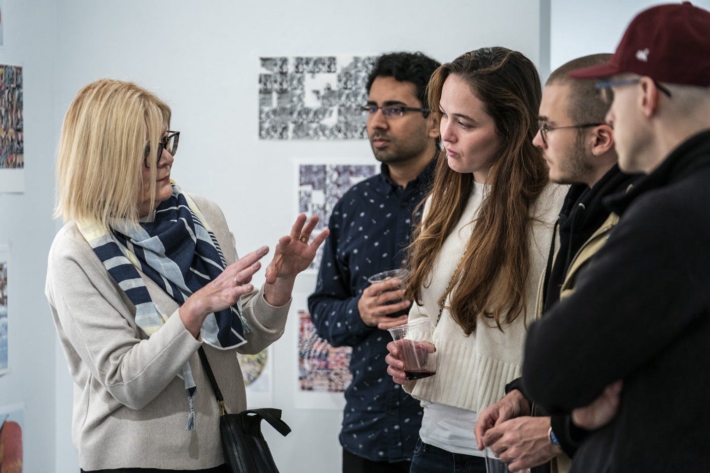 A woman talking to a group in an art gallery.