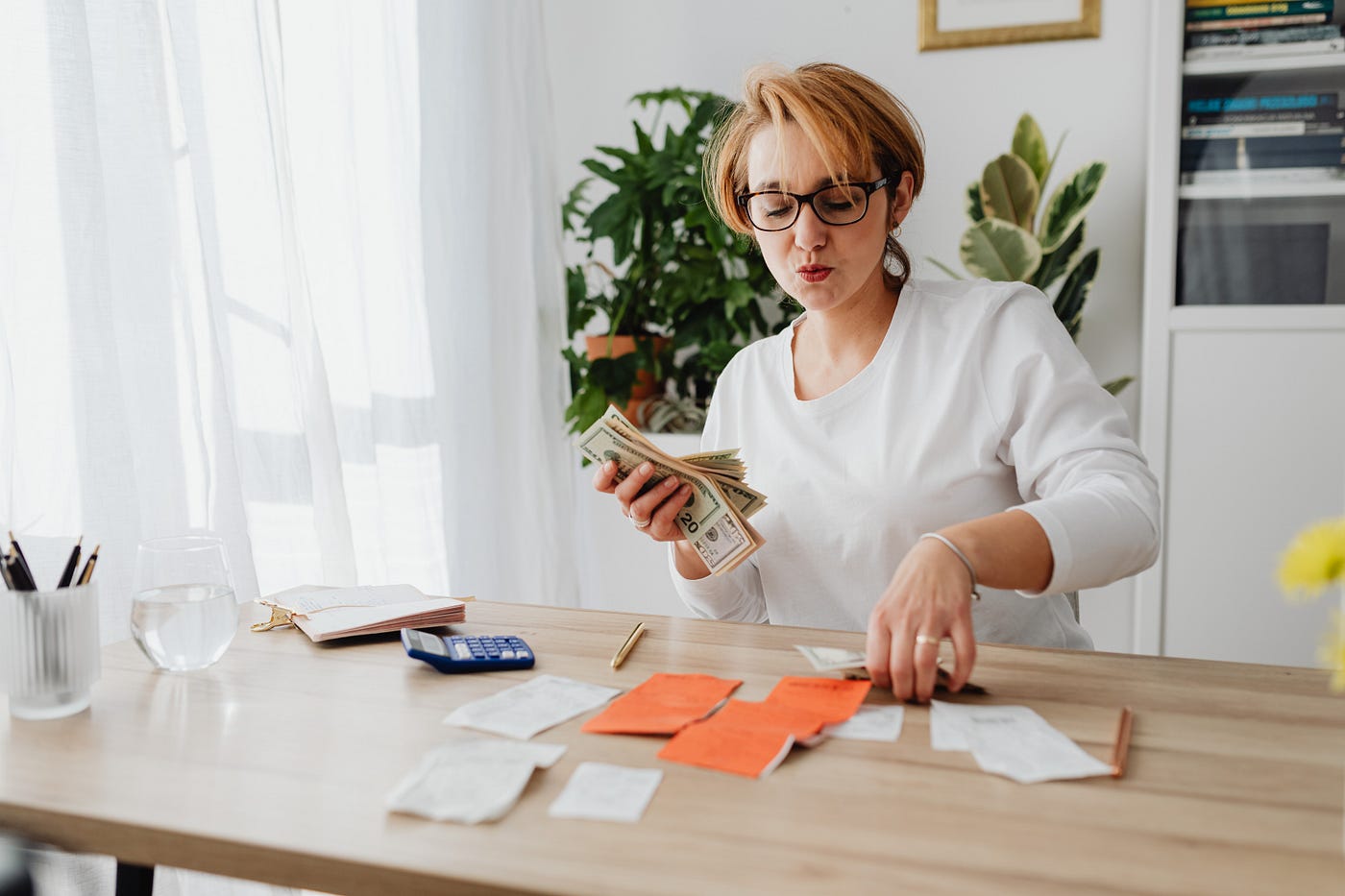 woman sitting at desk counting money