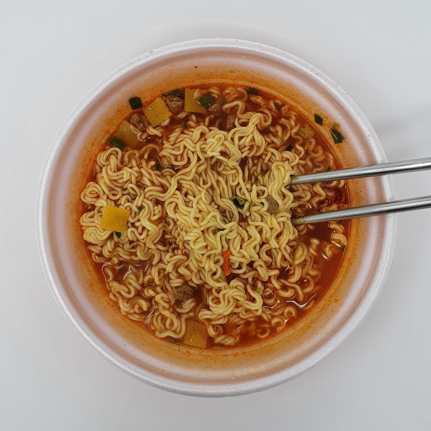 A finished bowl of Paldo King Ttukkeong Instant Noodles still in the bowl with chopsticks.