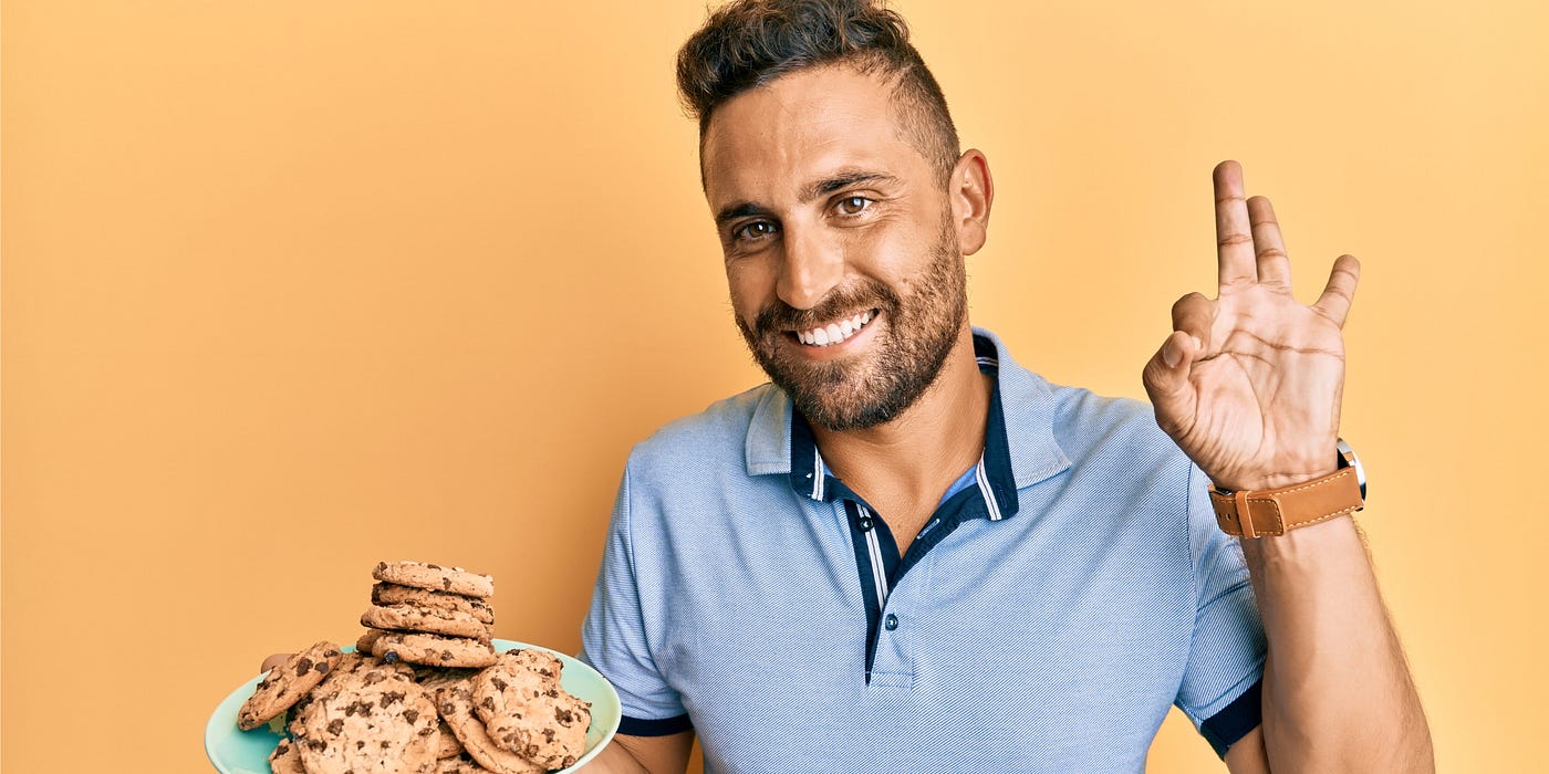 A man holding a plate of chocolate chip cookies. Courtesy of shuterstock.com / Krakenimages.com