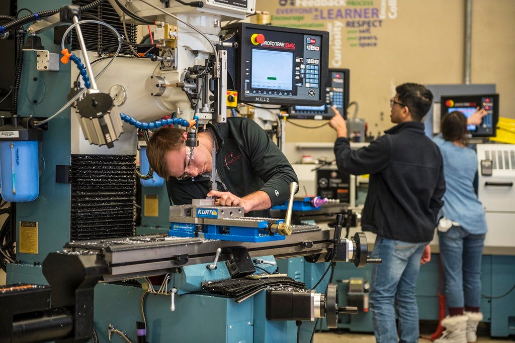 People focusing on electronic and manual tasks in a makerspace