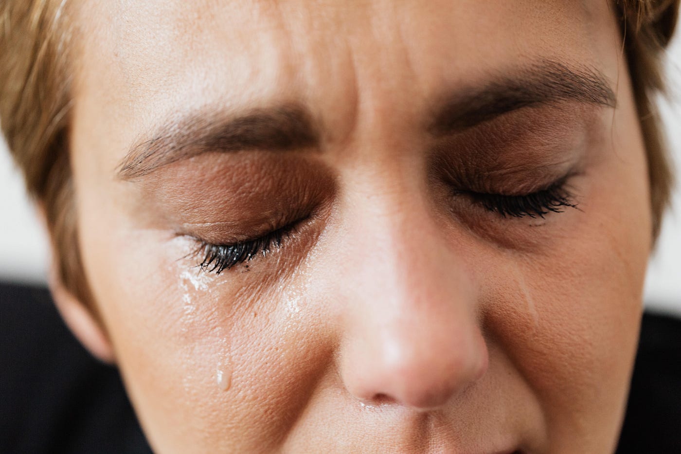 Close-up of woman’s face with tears.
