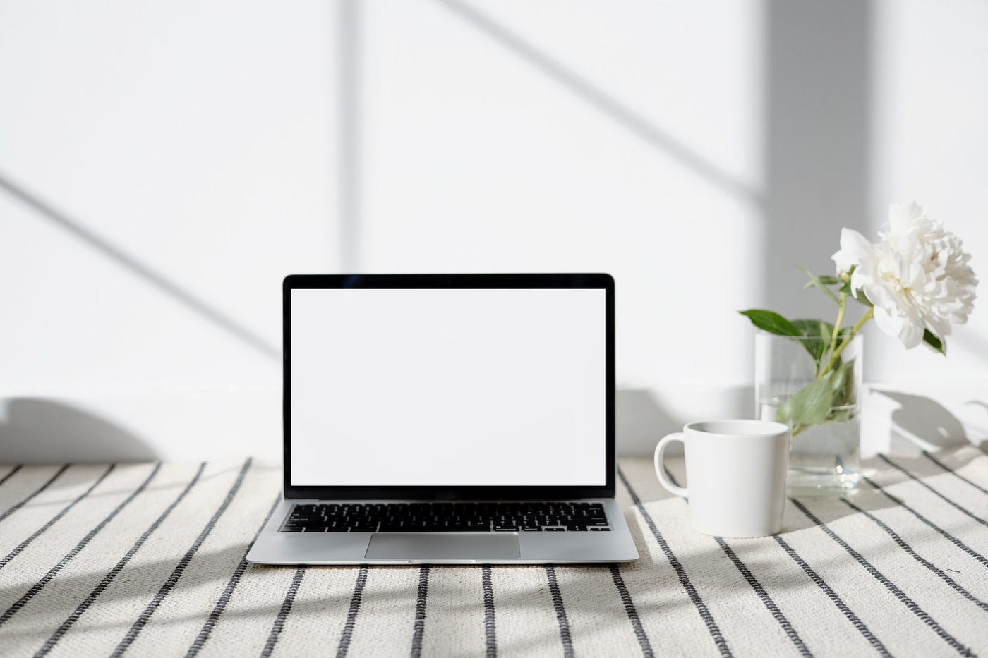 Laptop sitting on minimalist workspace.