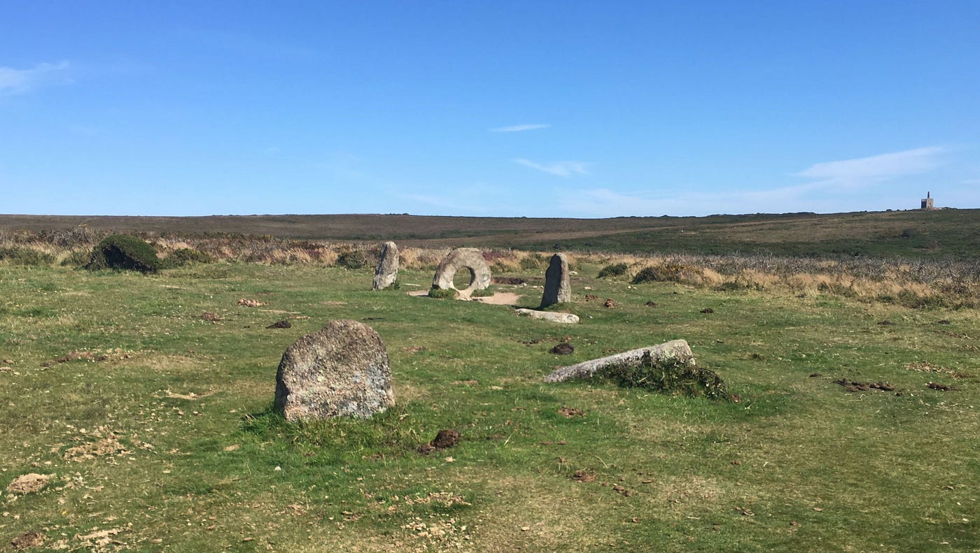 A hollowed out rock in the middle of an expansive, empty field.