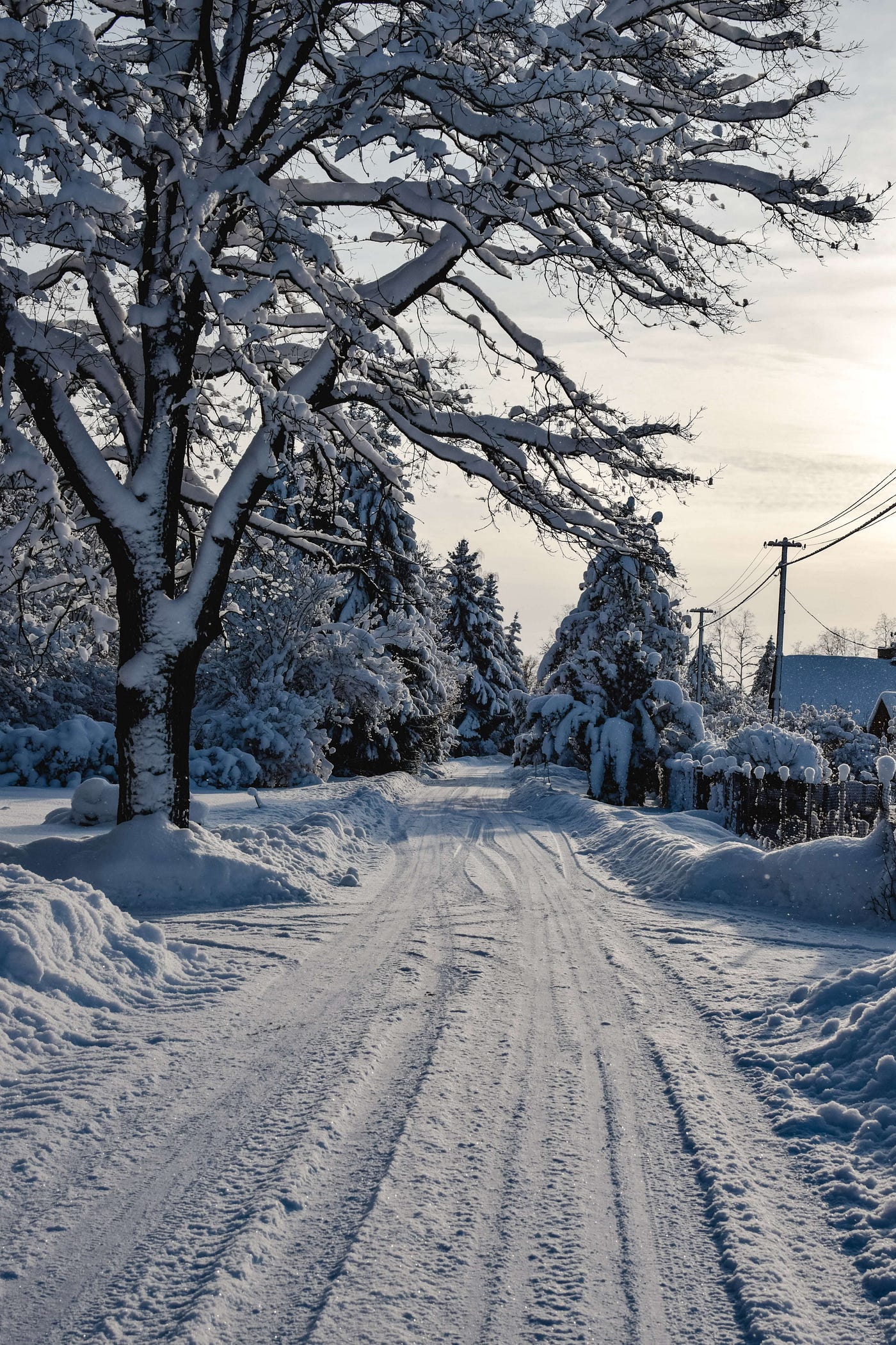 A snow covered road in winter with tyre marks