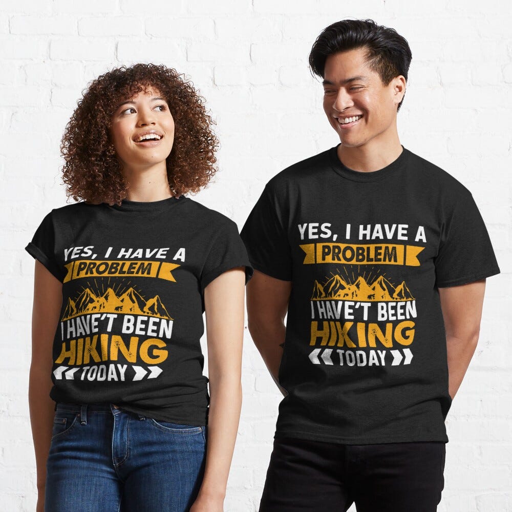 Man and Woman Wearing a black classic t-shirt with amazing illustration and text saying “yes I have a problem I haven’t been hiking today”.