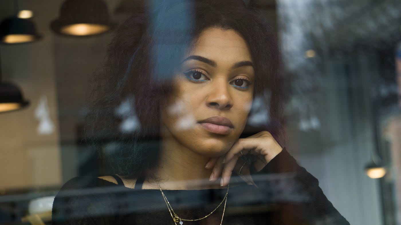 Mixed-race woman looking out a window.