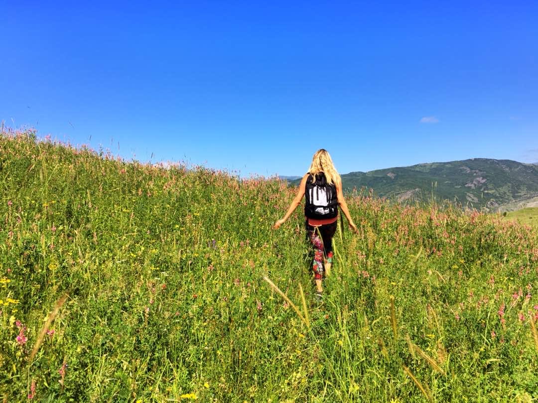 Sal walks away from camera through wildflowers in the mountains of Azerbaijan in 2018