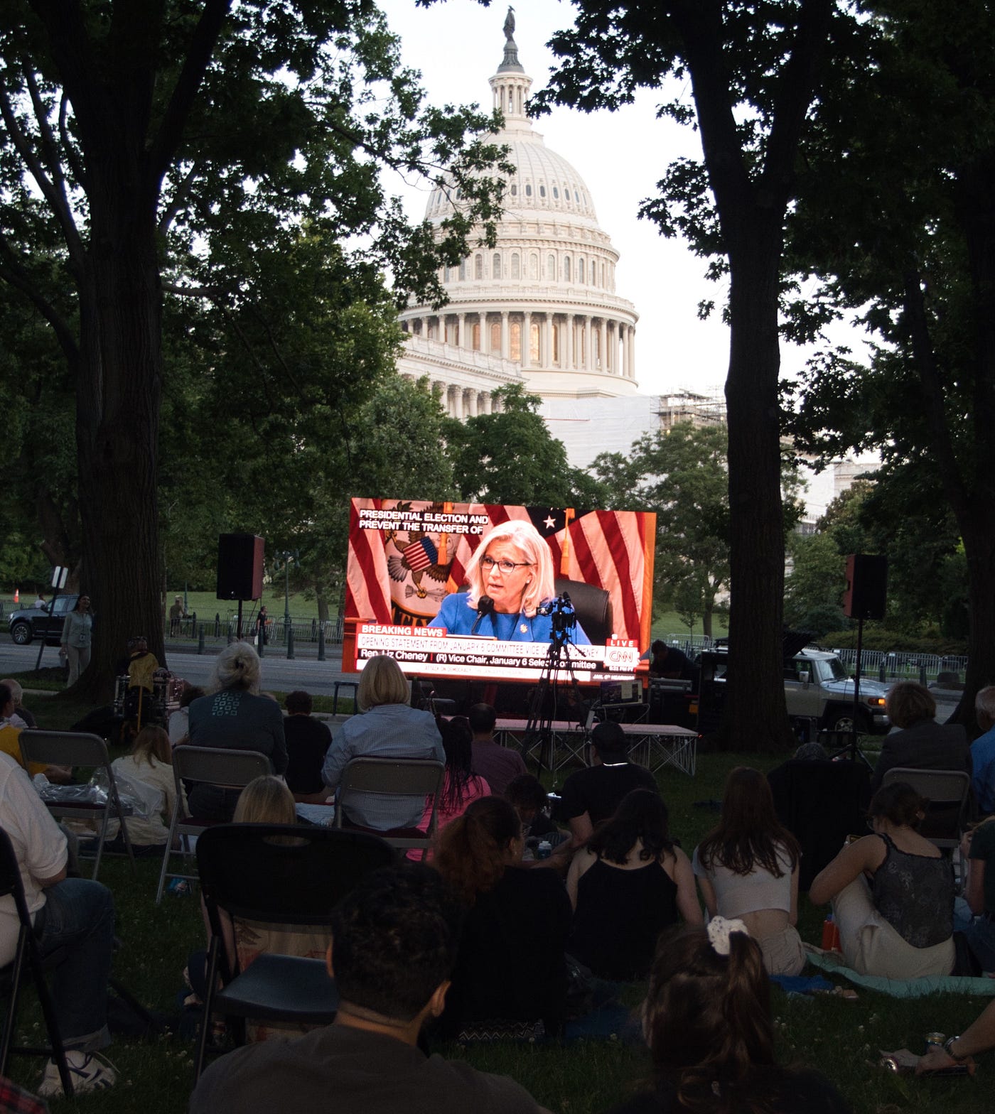 A crowd of people gathers near the U.S. Capitol to watch the first hearing of the January 6 committee on June 9, 2022.