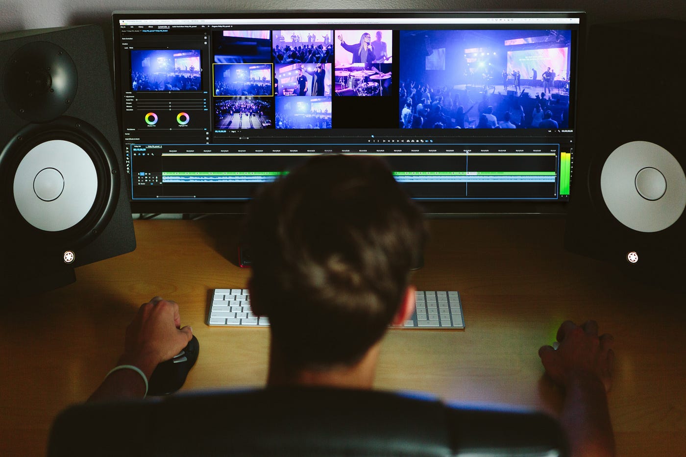 Man editing video in front of monitor and speakers