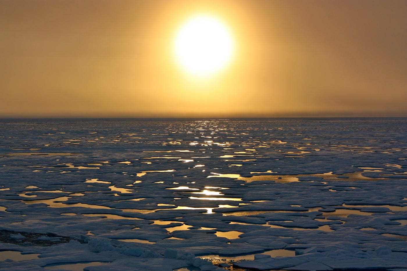 Reflection of a low angle sun over snow and ice and open water.