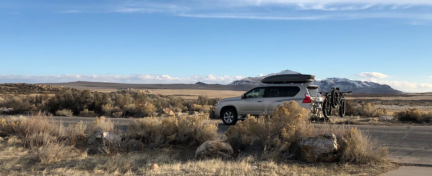Car loaded up with supplies for a grown-up gap year with mountains in the distance.