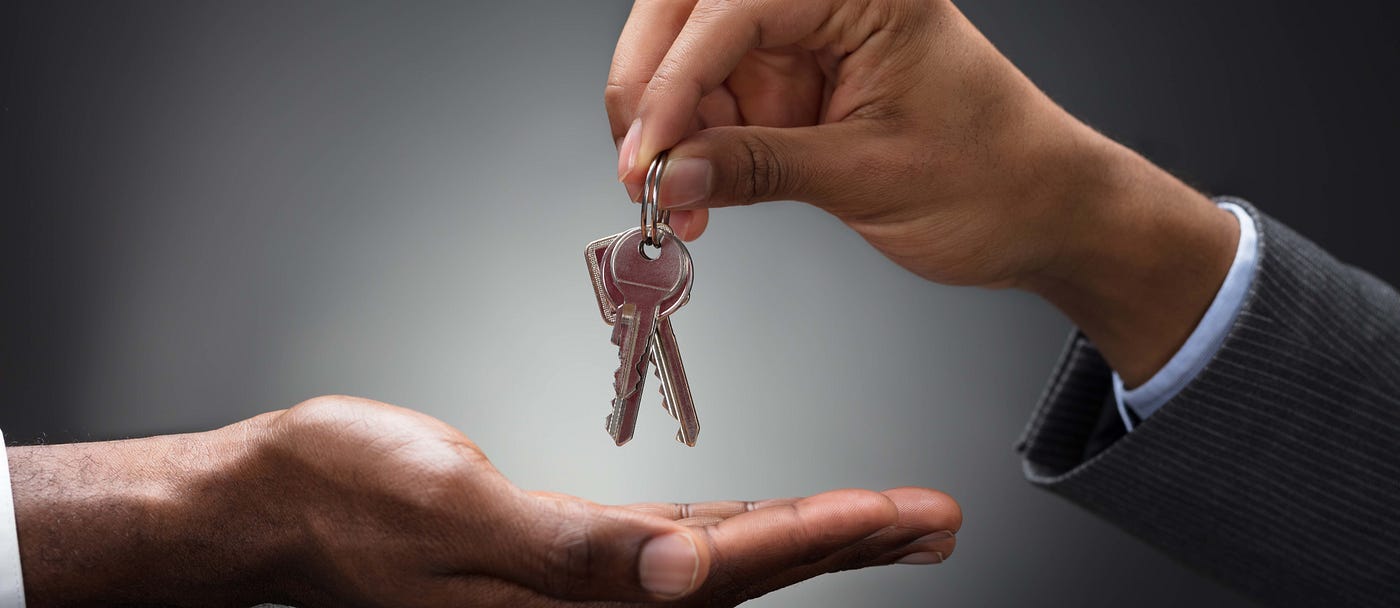 A hand handing off keys to another hand