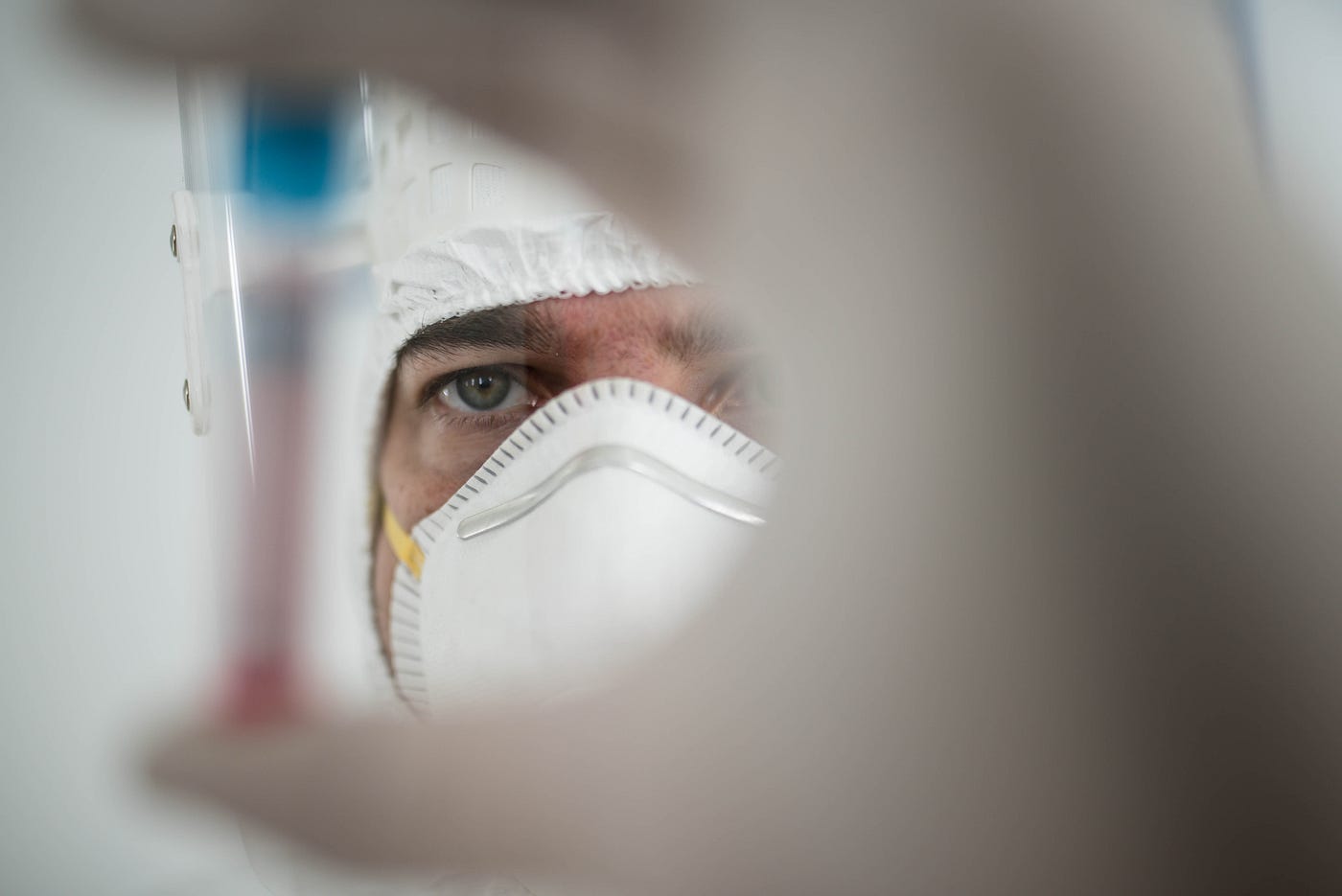 In a chemistry lab, a male researcher holds a tube with the coronavirus virus.