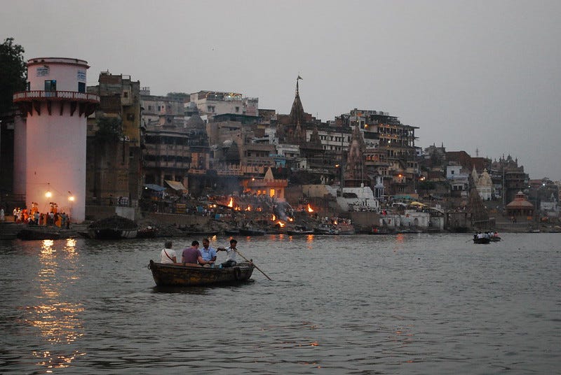 Scene at dusk from the holy city of Varanasi, open air funeral pyres on the bank of the River Ganges