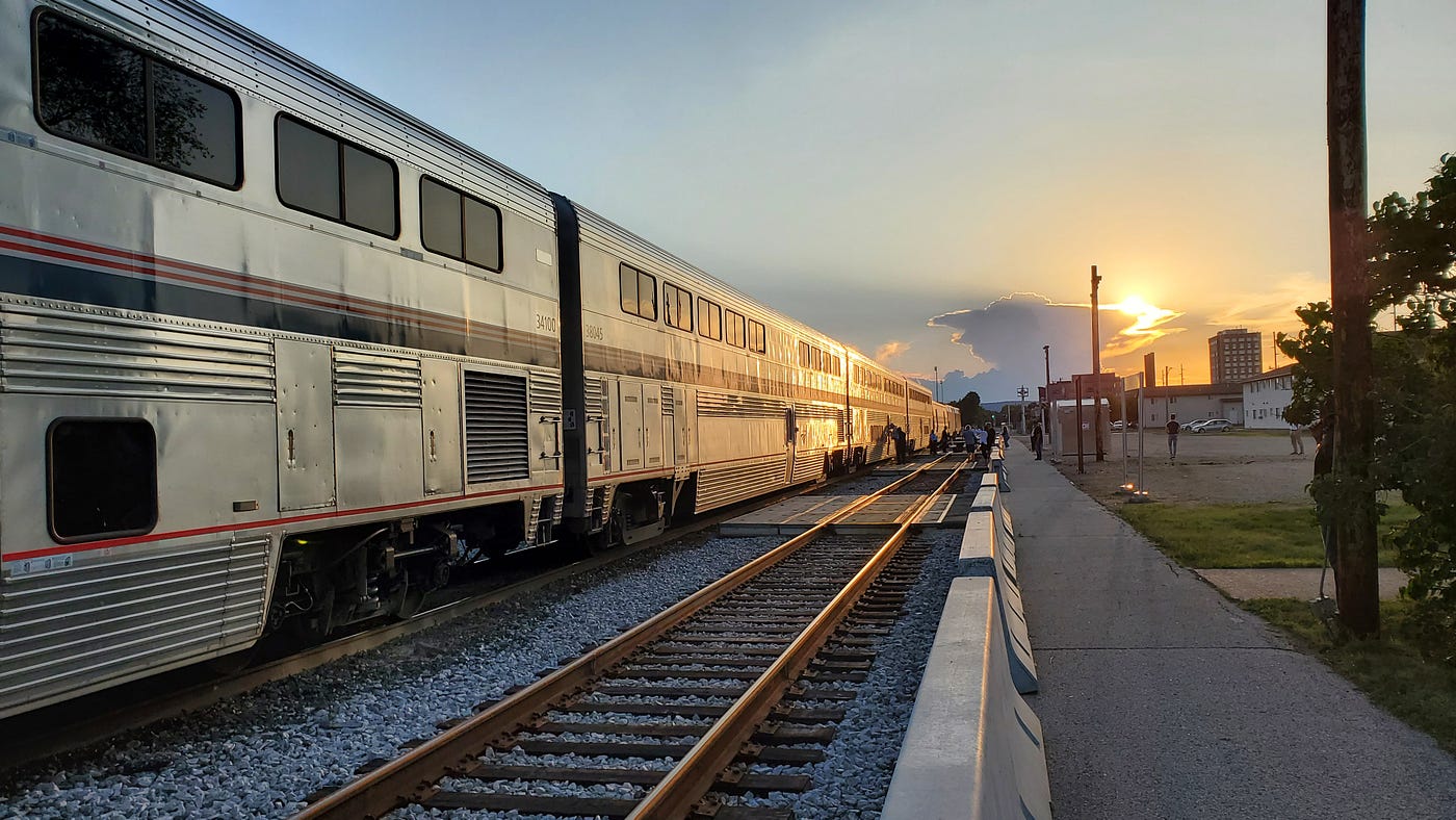 A view down the tracks during a stop on the way out west. sunset in the background