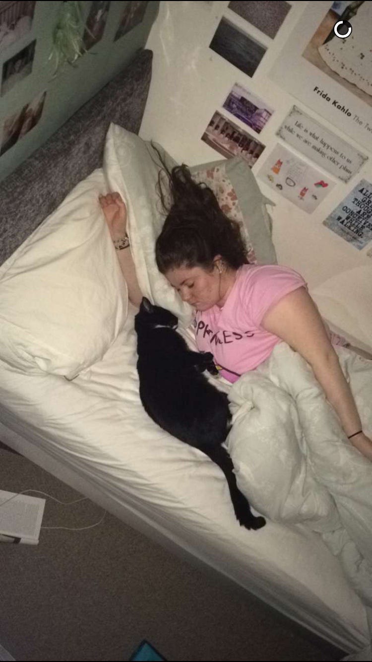 A photo of me lying in my bed asleep with my cat lying asleep very close to me facing me