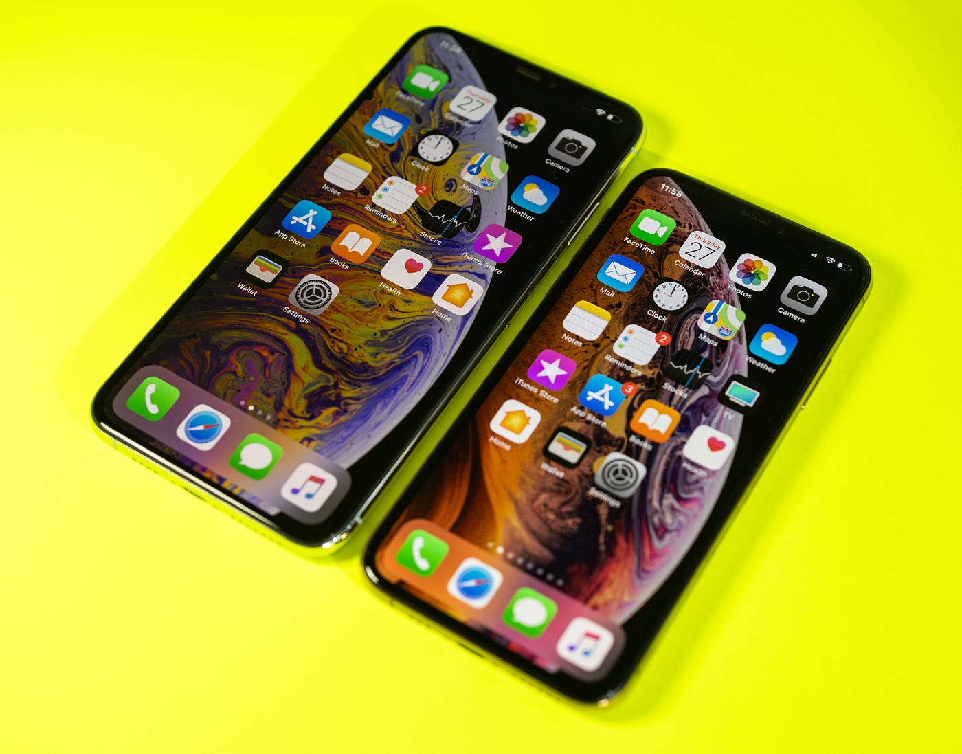 The new Apple iPhone Xs and Xs Max against a bright modern neon yellow background.