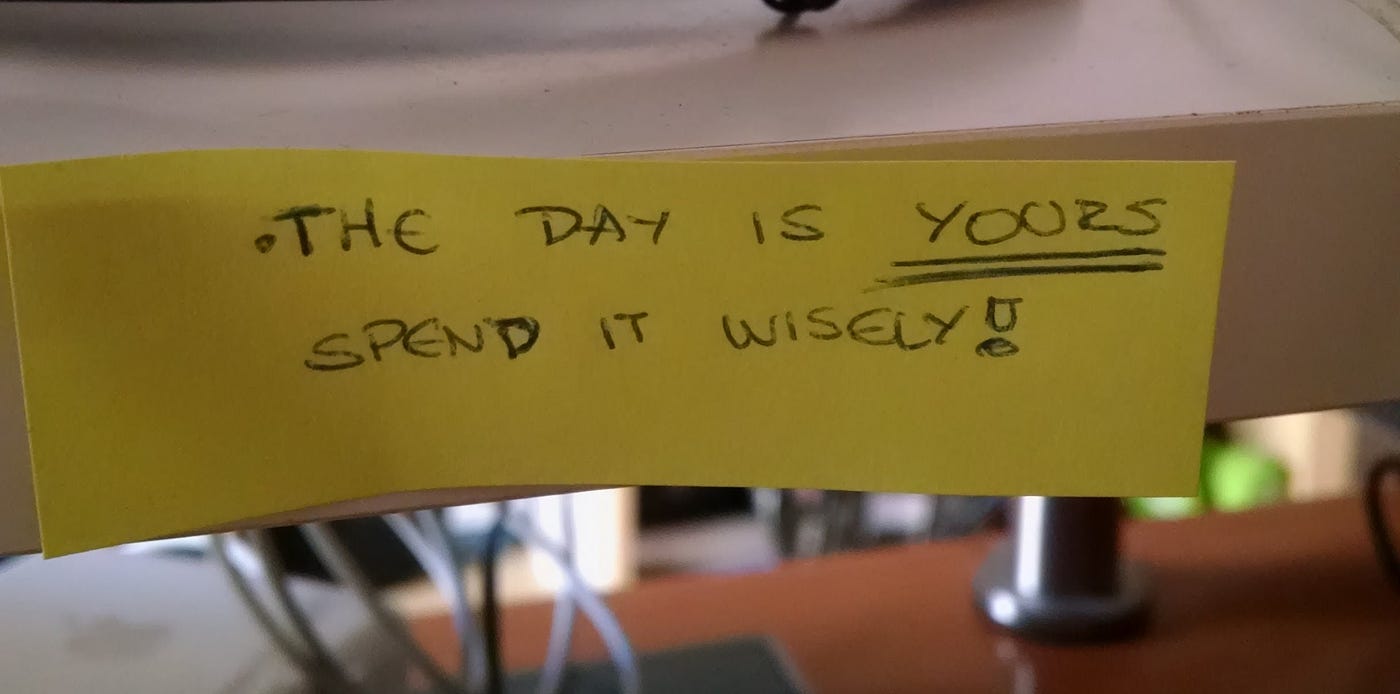A post-it reading “The Day is yours spend it wisely!”