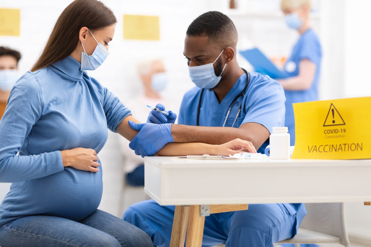 Pregnant Woman Receiving a Coronavirus Vaccine from a health provider