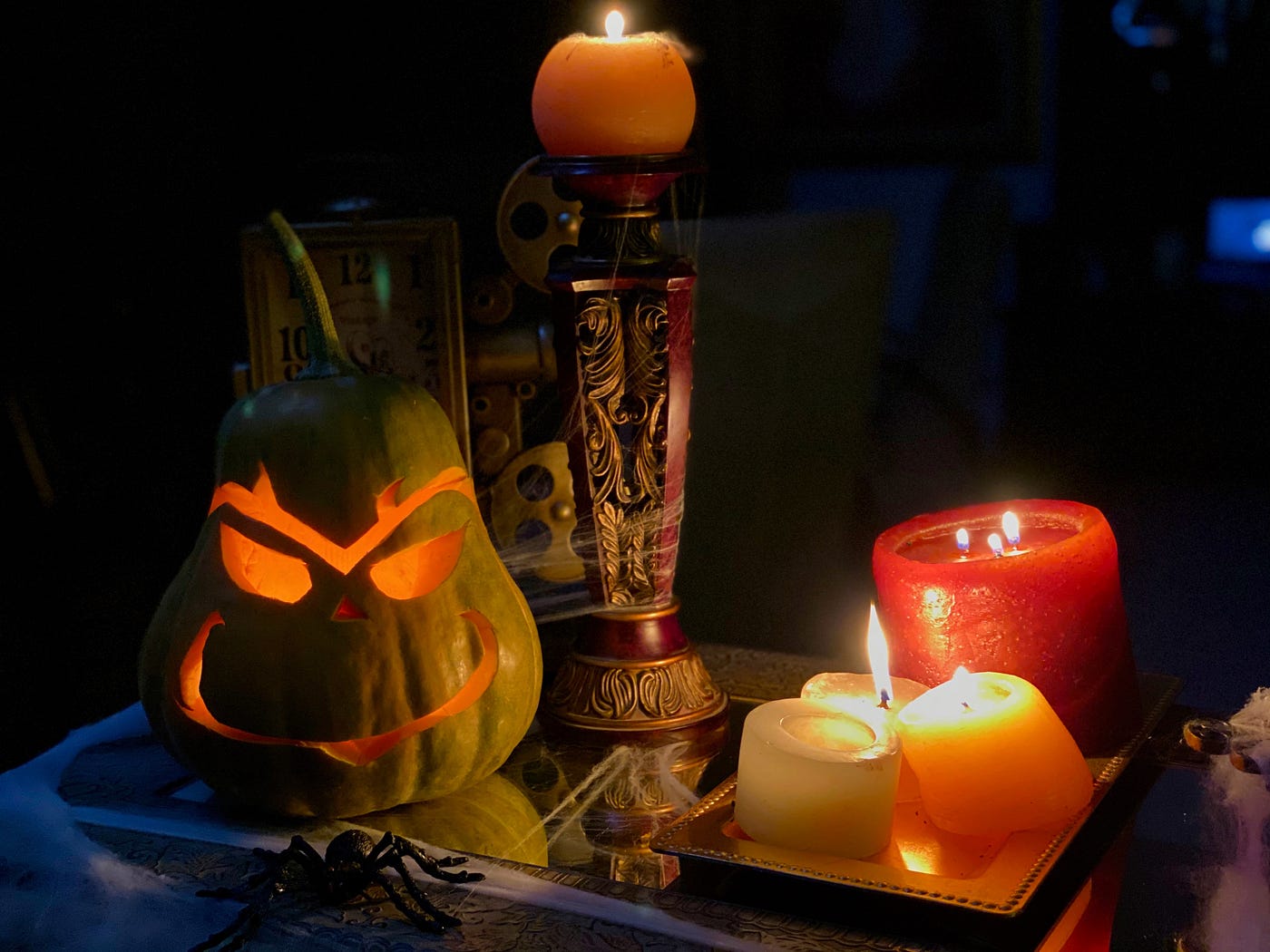 Candles and a jack-o-lantern carved with the face of the Grinch.