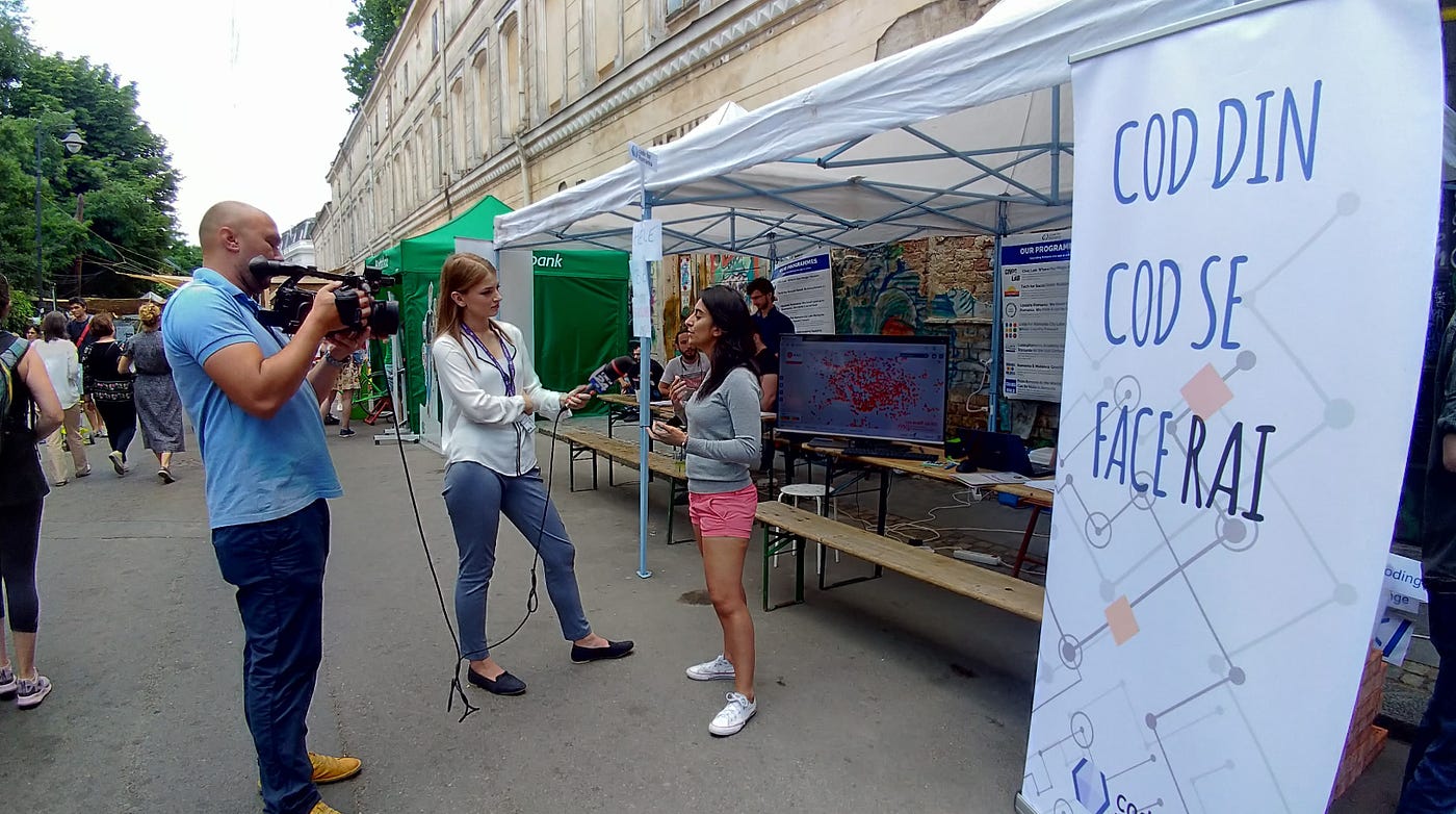 A person is interviewed by a TV journalist outdoors.