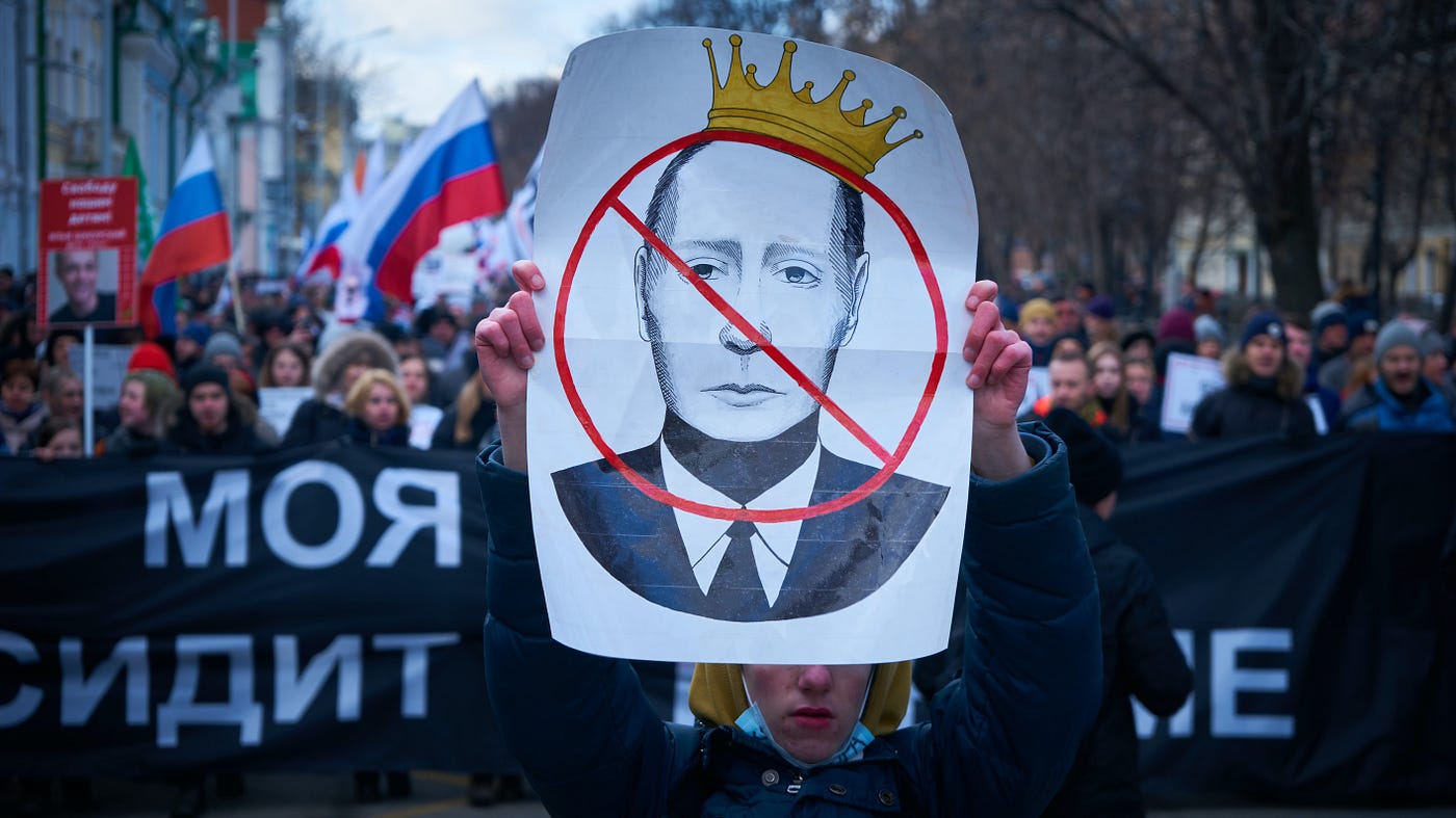 A protester holds a banner criticizing Vladimir Putin