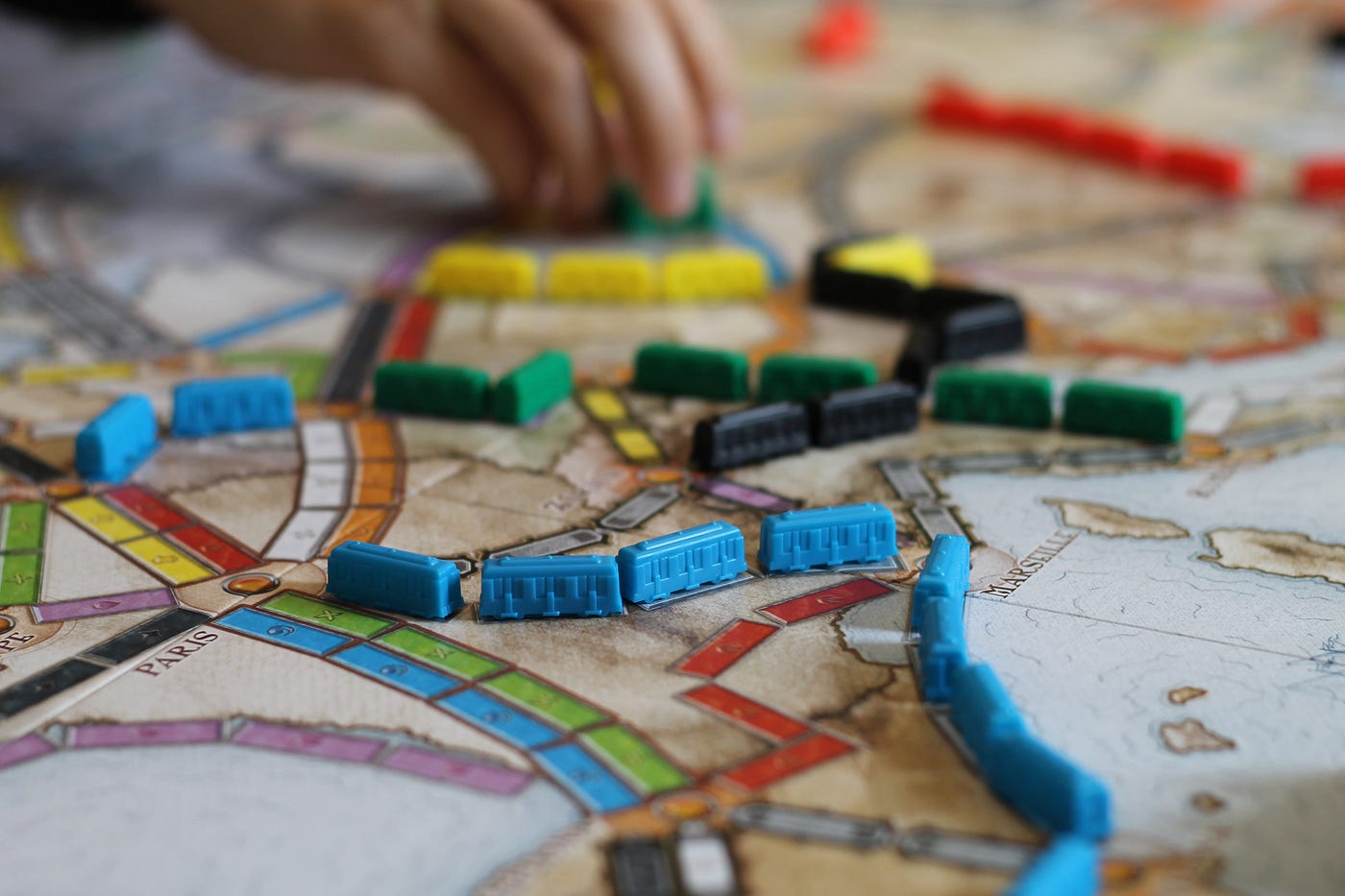 Board game map with train lines filled with tiny trains of multiple colors