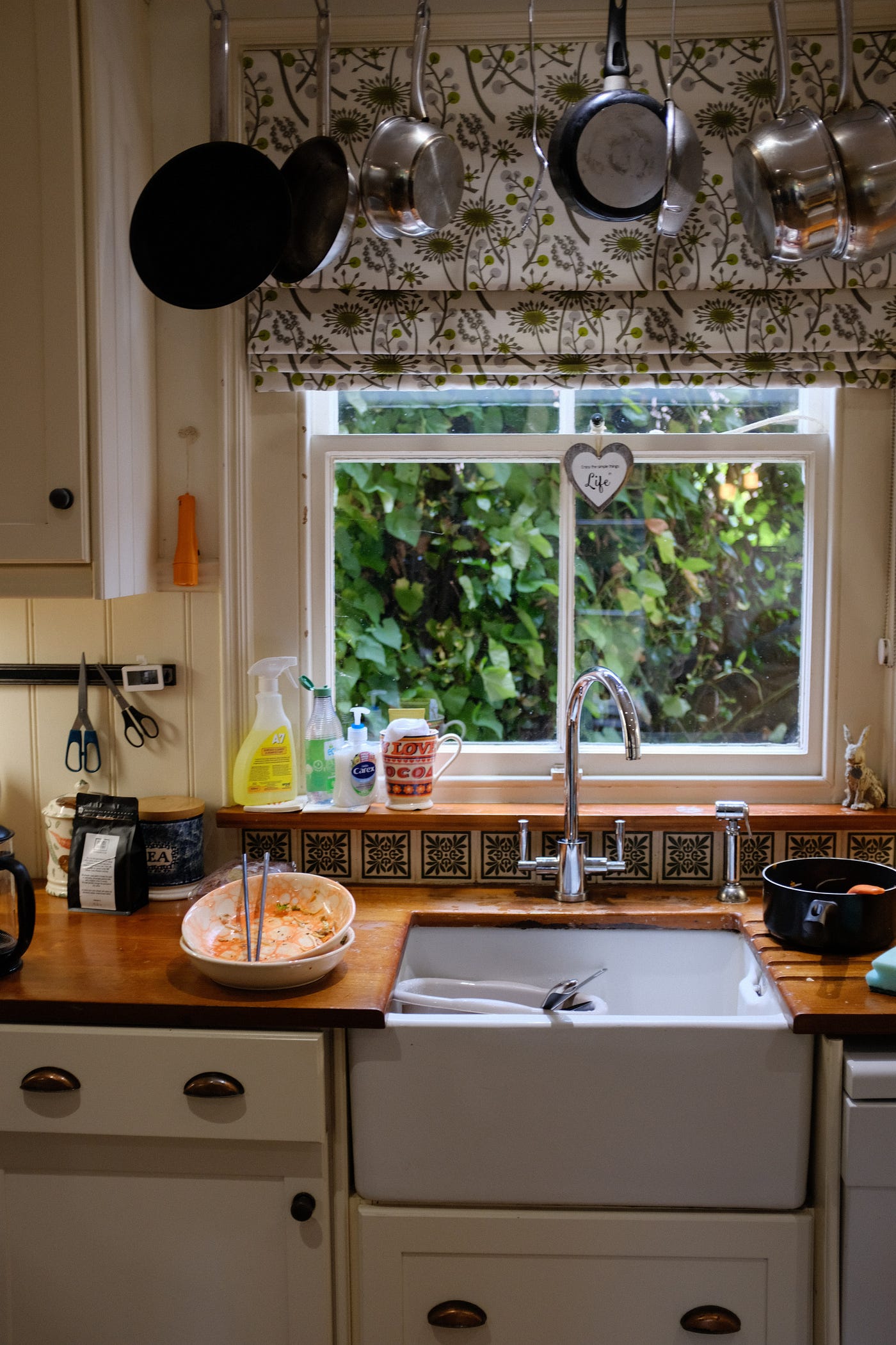 kitchen counter with sink, dishes, and large window.