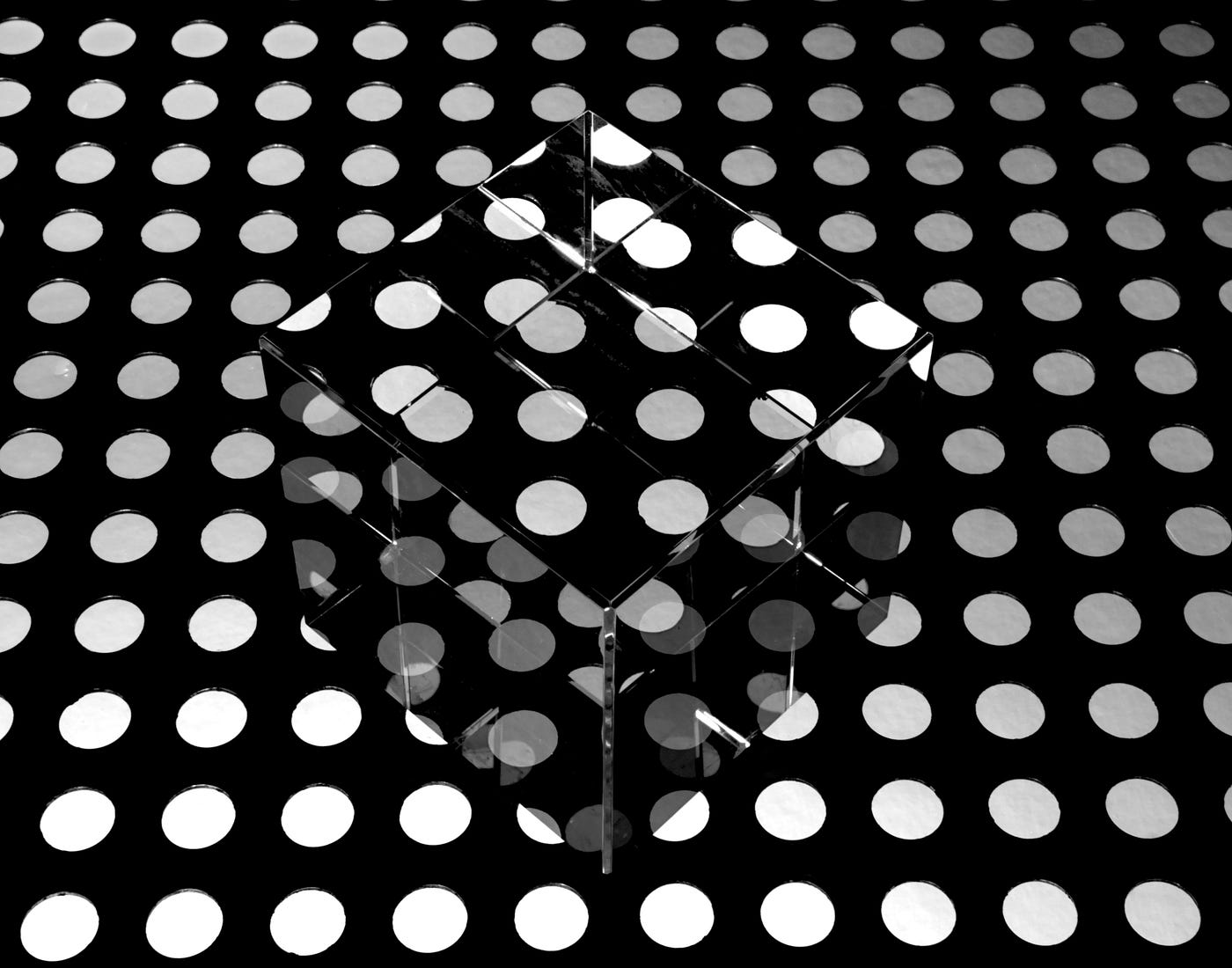Mirrored cube in a black and white spotted background