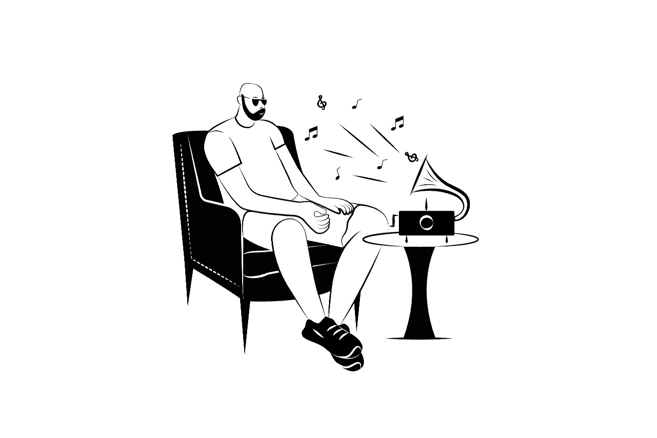 A man sitting down, listening to music from a music player in front of him.