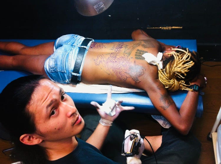 Aurora Mizutani being tattooed by a craftsman at Hirakata Tattoo Studio 2013