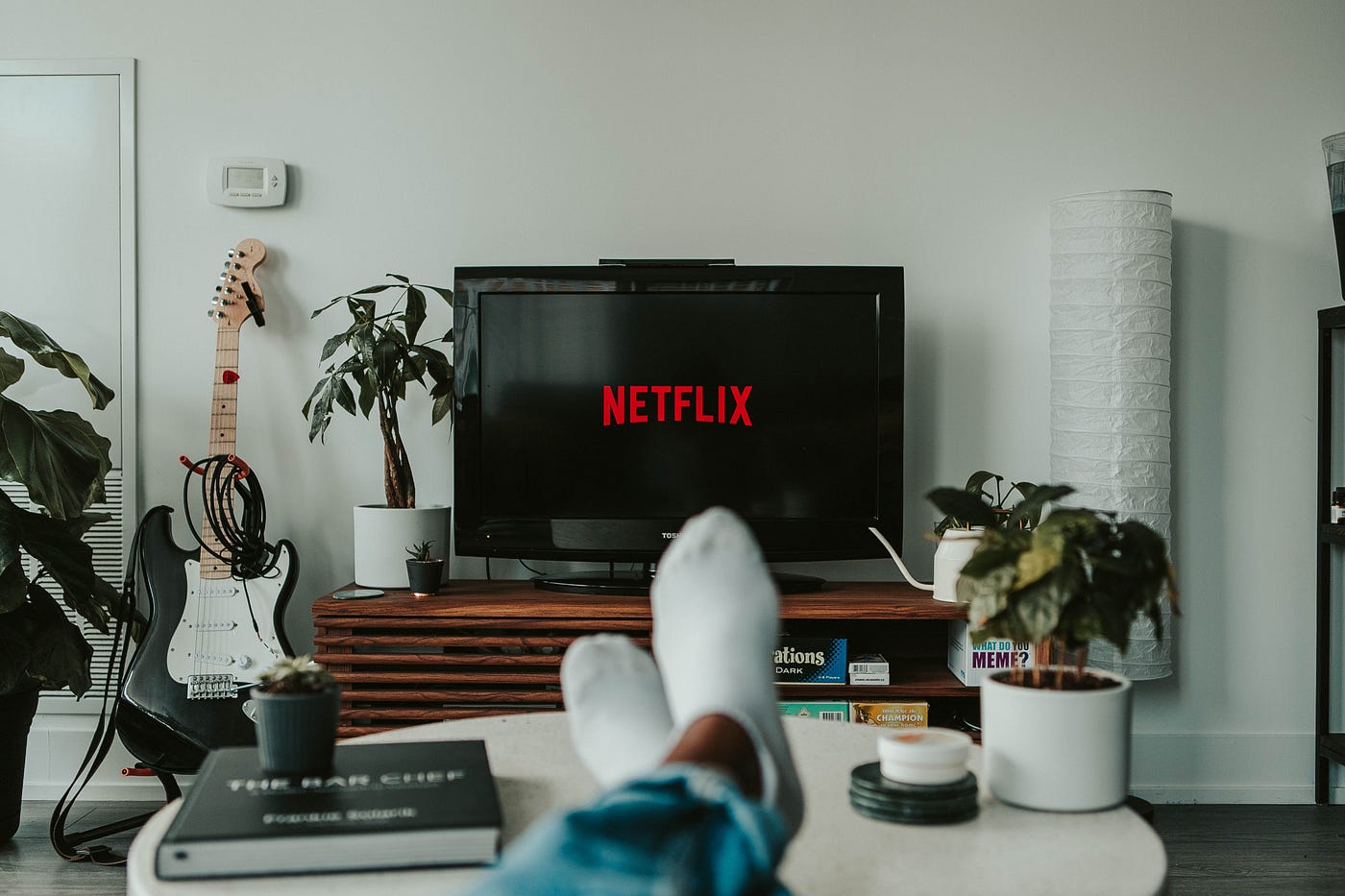 A person sitting with feet on coffee table watching Netflix