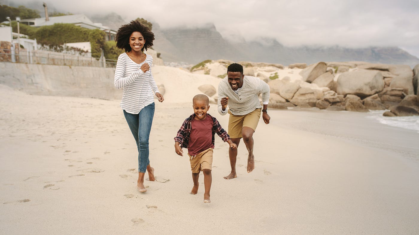 Family running along the beach