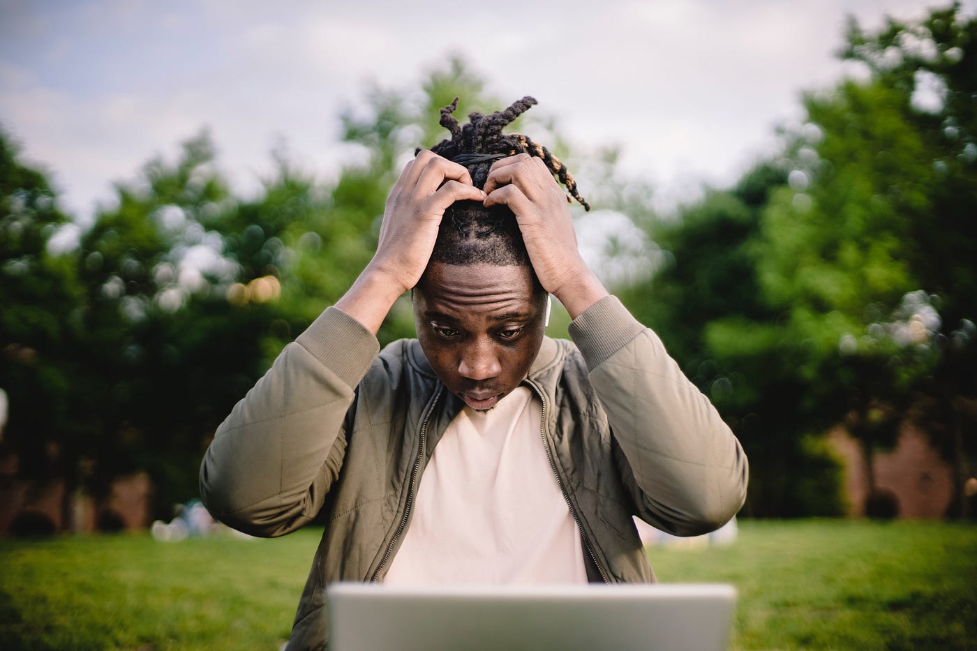 Man with hands on his head in a park, image for Why ‘Show Not Tell’ Is Terrible Writing Advice article