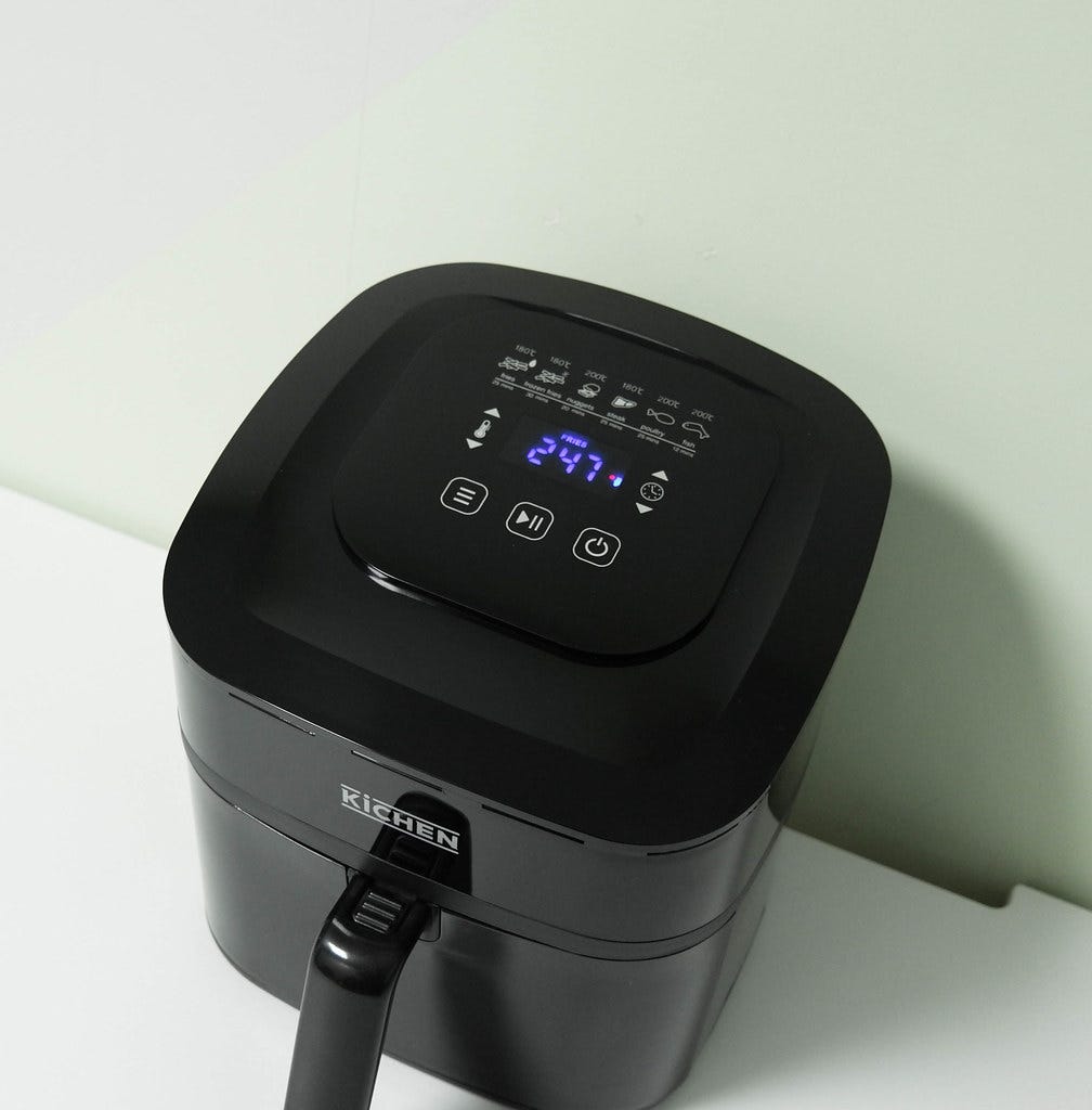 photo of a black air fryer on a white counter