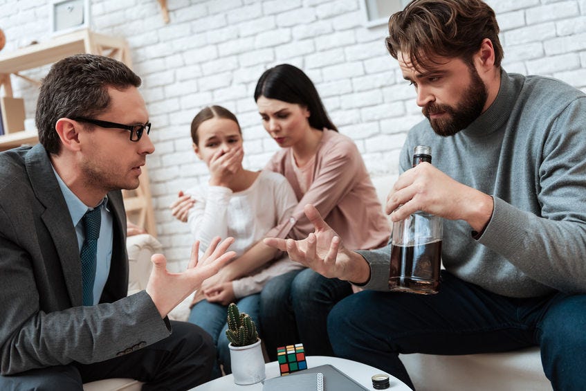 group of people, one drinking alcohol from a bottle