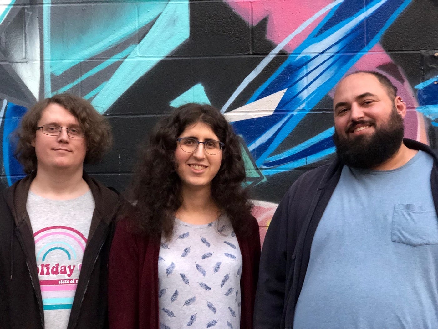 Three of the fired Google organizers standing against a colorful backdrop.