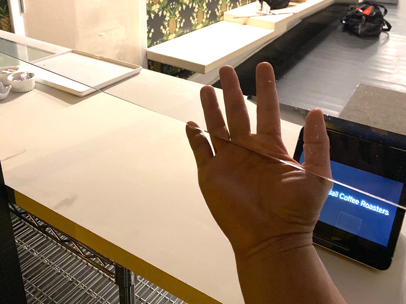 a hand is shown, half of it behind what looks like a pane of glass.