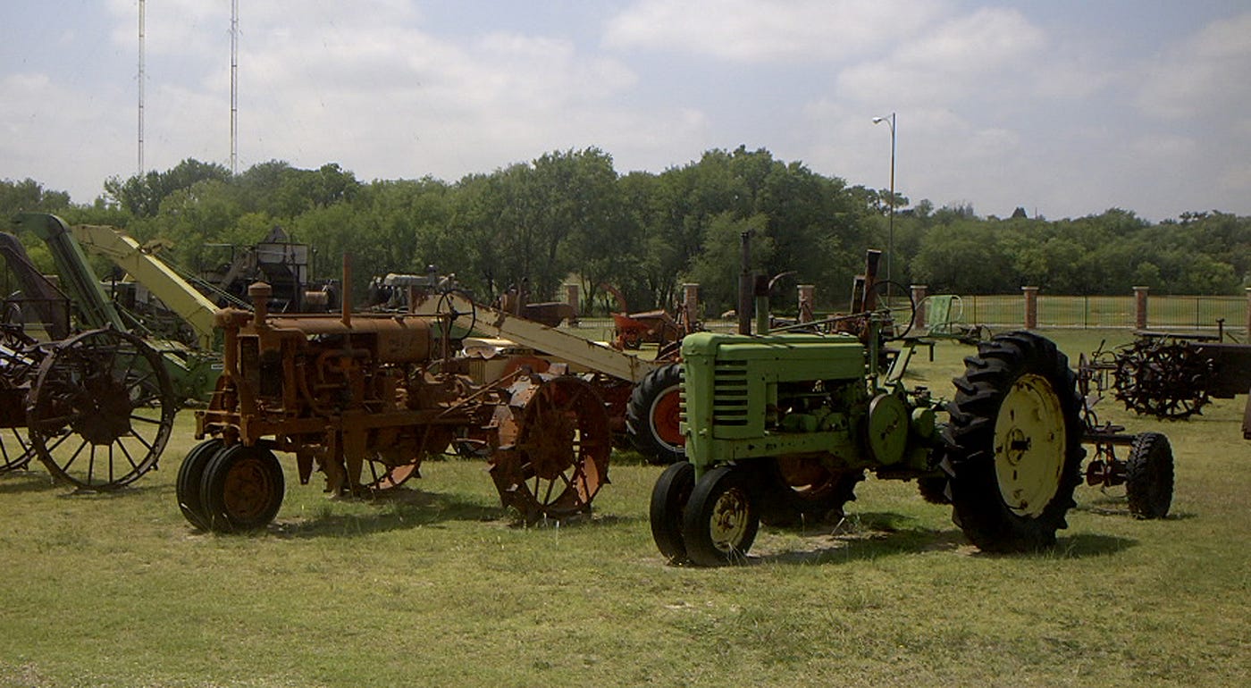 Image of old farm tractor’s lined up in a field on display