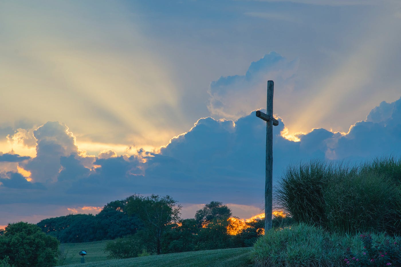 A cross in front of a cloud.