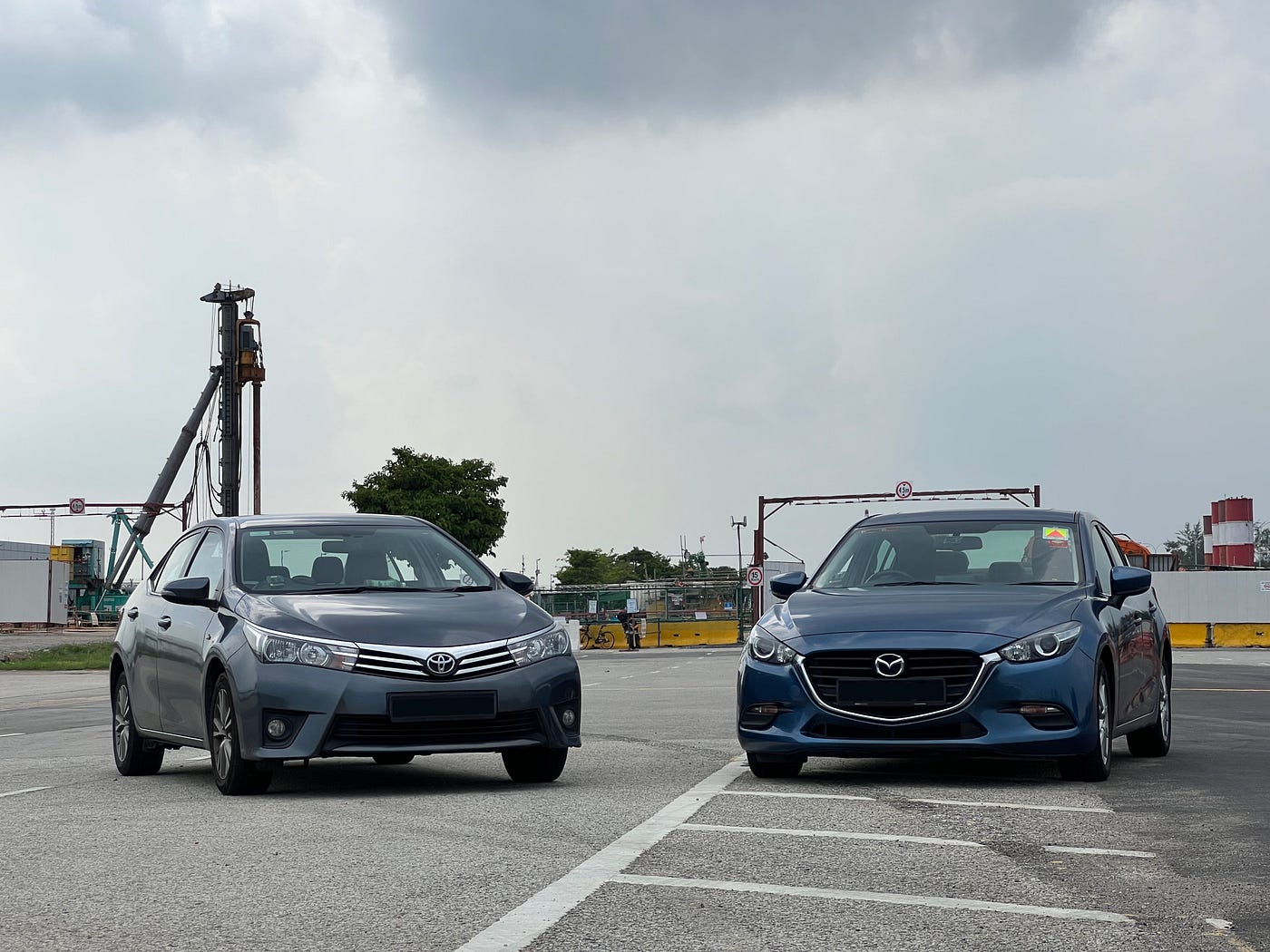 A Toyota Corolla Altis and a Mazda 3 at Aviation Park Road for a road trip.