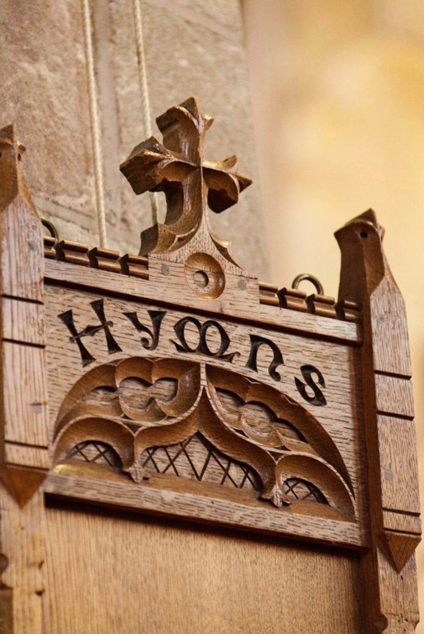 Color photo of the word Hymn carved in wood, probably inside a church.