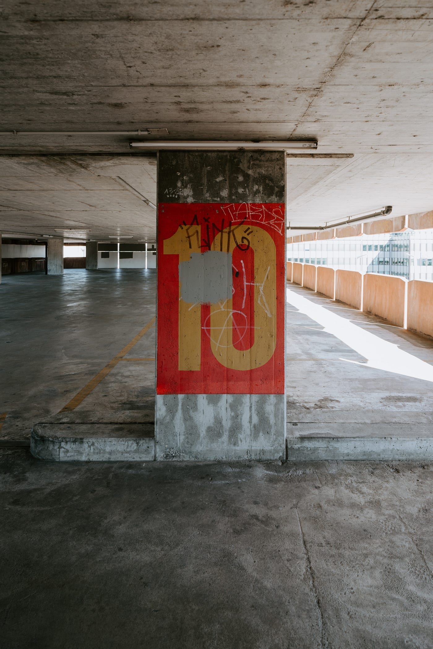 A big number ten painted on a wall in a car park