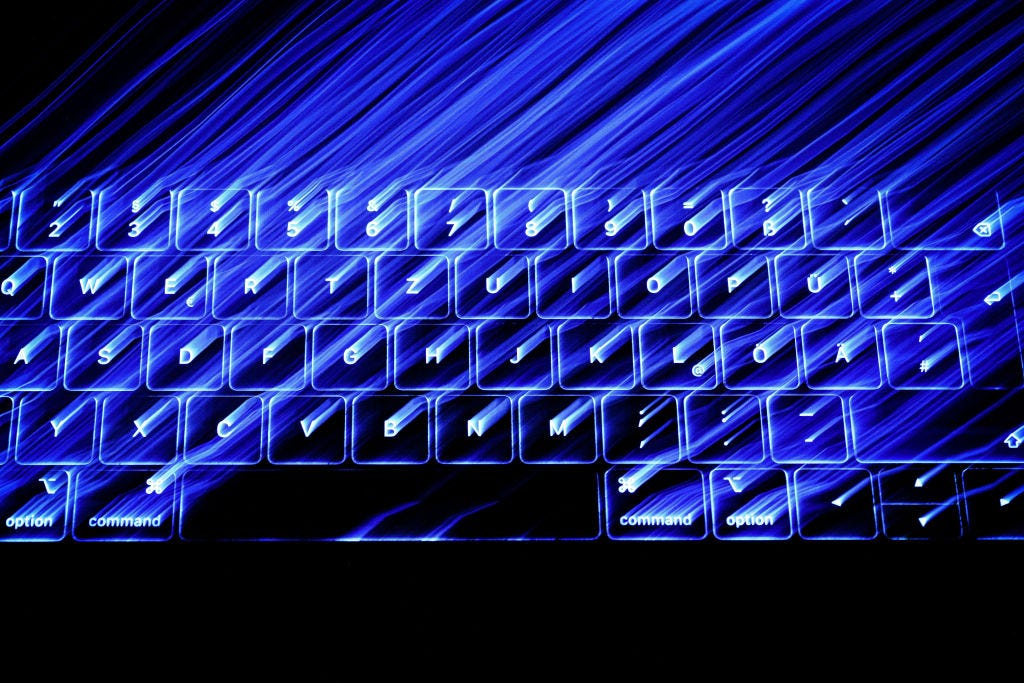 A photo of an illuminated Mac keyboard in the dark.