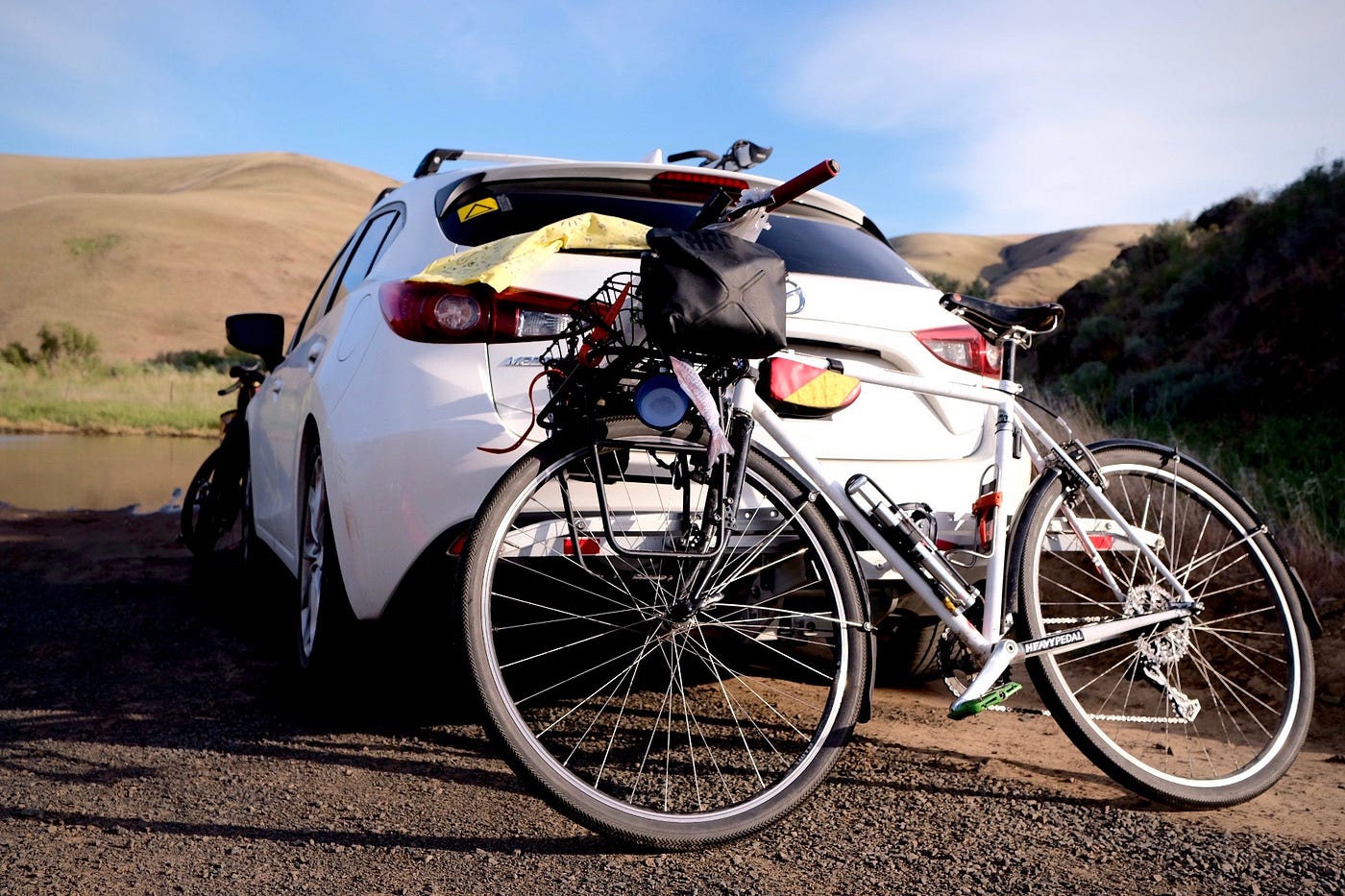 a bike is leaned against the rear hatch of a car