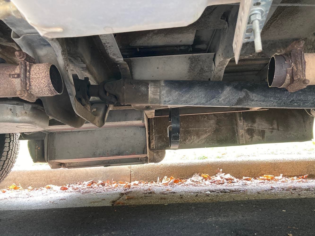 the exhaust pipe under a short school bus, with a few feet of the pipe sawed out and missing where the catalytic converter was stolen.