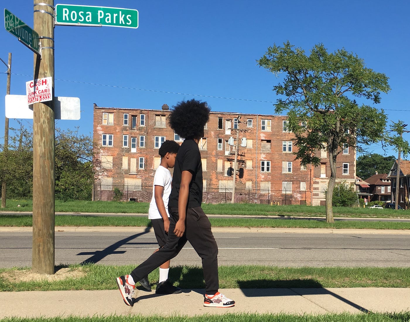 A photo of two Black youths walking down a street in Detroit.