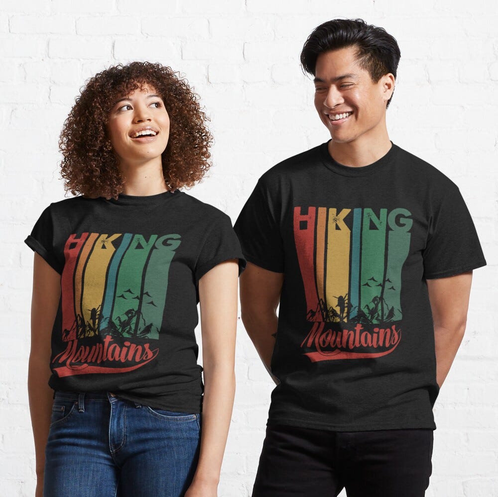 Man and Woman Wearing a black classic t-shirt with amazing illustration and text saying “hiking mountains”.